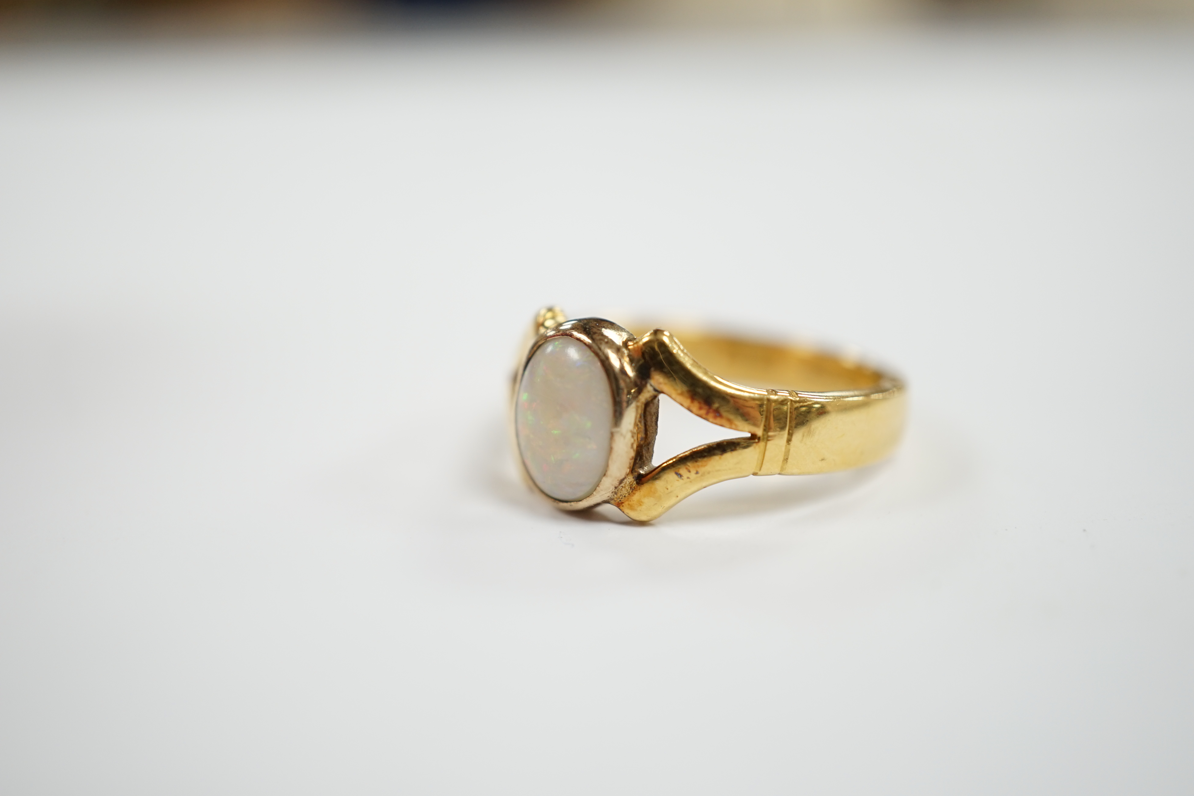 A George V 22ct gold and single stone cabochon white opal set ring, size P/Q, gross weight 6.5 grams.